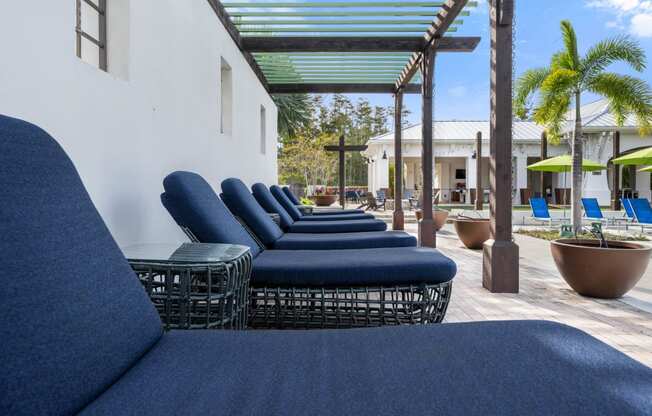 an outdoor lounge area with blue couches and tables