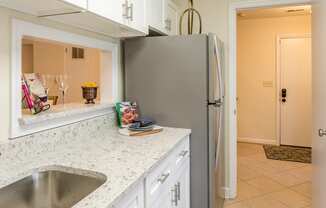 a kitchen with white cabinets and a sink and a refrigerator