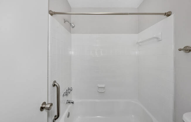 A white bathroom with a tub and shower.