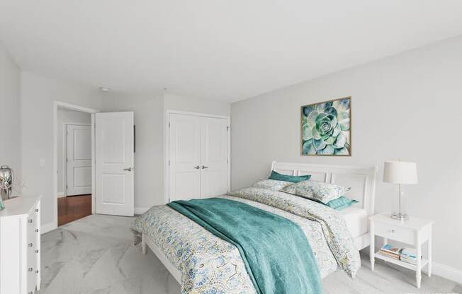 A bedroom with a bed, nightstand, and two doors.