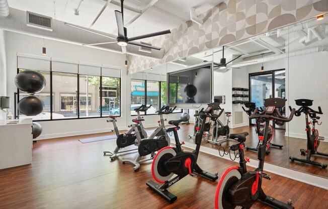 the gym has plenty of exercise bikes and other fitness equipment at Link Apartments® 4th Street, Winston-Salem