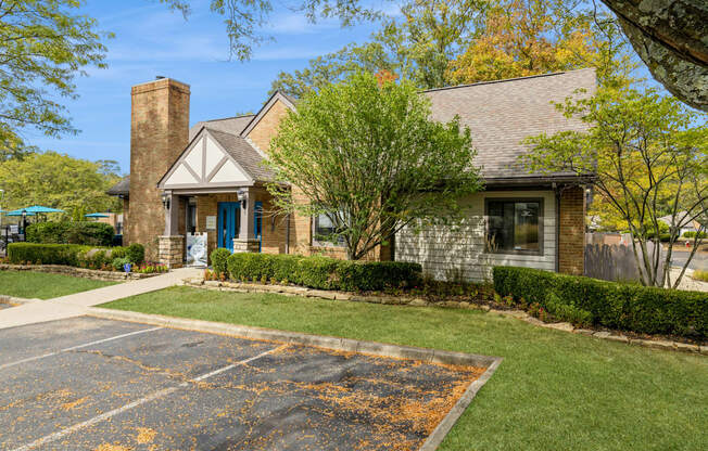 the front of a brick house with a driveway and lawn