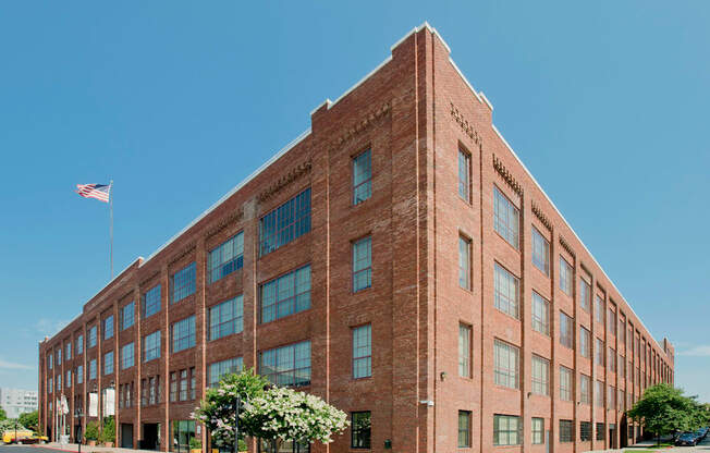 a large brick building with an flag in front of it at Tindeco Wharf, Baltimore