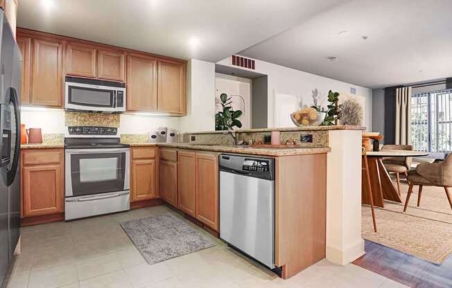 A kitchen with wooden cabinets and a stainless steel dishwasher.