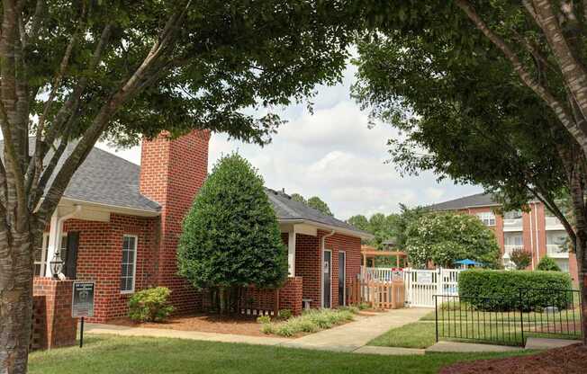 A red brick house with a black fence in front.