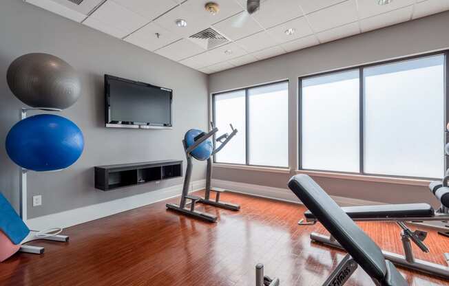 a fitness room with exercise equipment and a tv