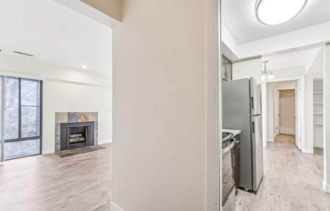 A modern kitchen with a fireplace and a refrigerator.