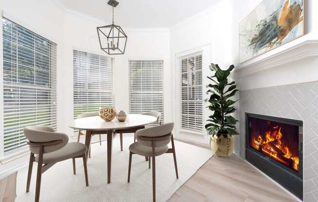 a living room with a fireplace and a table and chairs