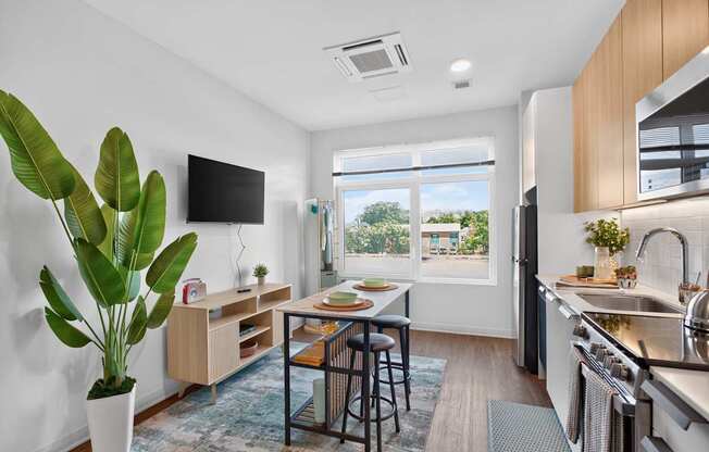 A modern kitchen with a dining table and chairs in the middle at The Indie in Allston.