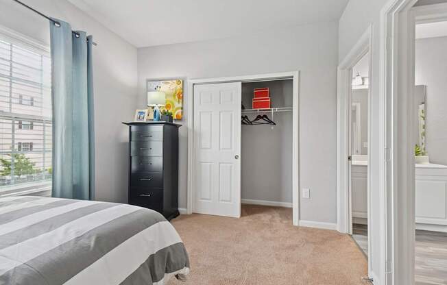 A bedroom with a bed, a dresser, and a wardrobe.