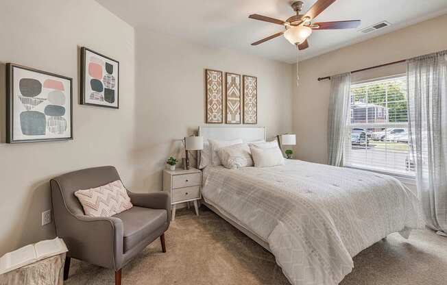 A bedroom with a large bed and a chair.