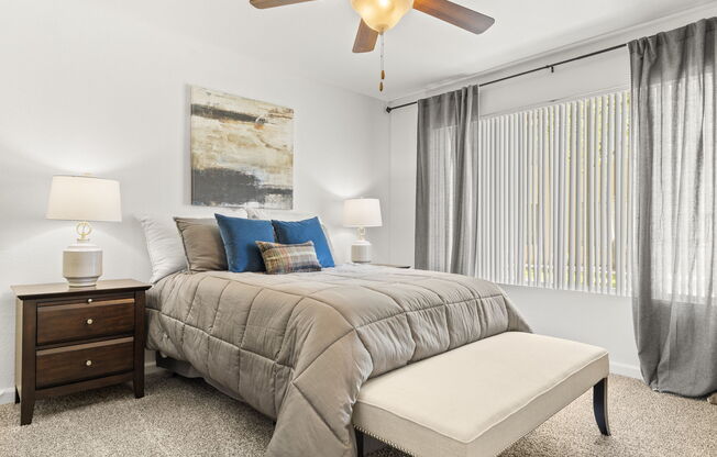 a bedroom with a bed and desk in a hotel room