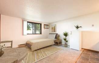 Mandan, ND Garden Grove Apartments.  a bedroom with a bed and a table