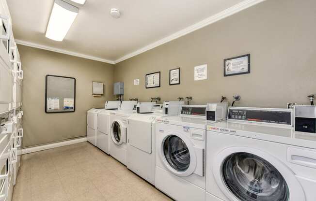 The Woods community laundry room with many washers and dryers in shared access room. 