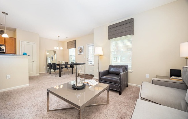 A living room with a glass coffee table in the center.
