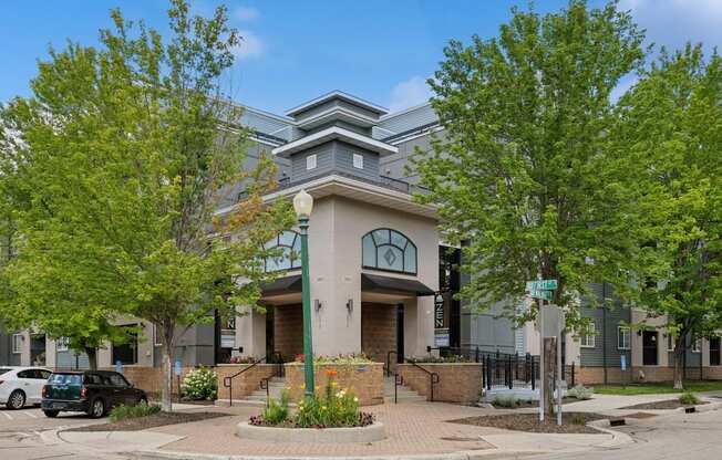 A modern building with a grey facade and a green tree in front.