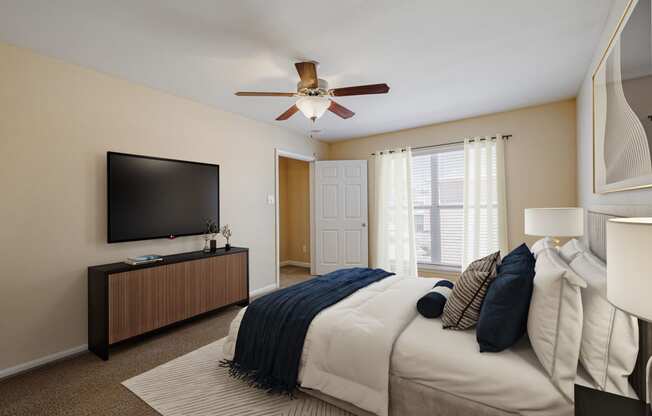 a bedroom with a large bed and a ceiling fan