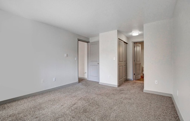 a bedroom with white walls and a carpeted floor