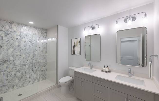 a white bathroom with two sinks and a shower  at The Belden Stratford, Chicago, IL