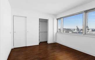 a bedroom with a large window and white walls