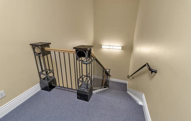 the upstairs landing of a home with a stairwell and a railing and a staircase at The Granite Works Apartments , Buffalo, NY, 14202