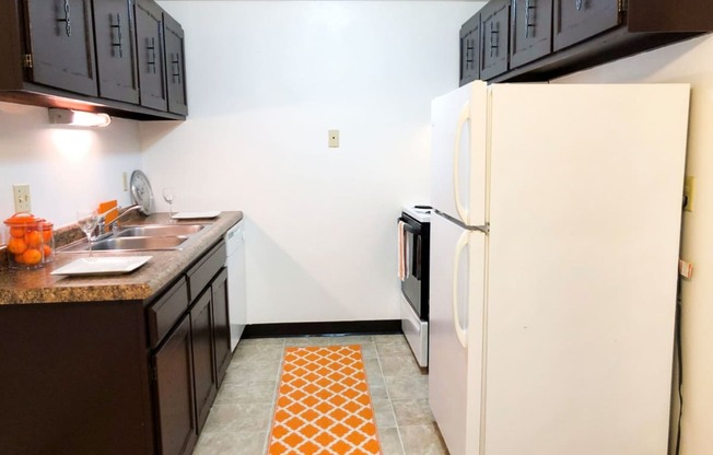 a kitchen with black cabinets and a white refrigerator