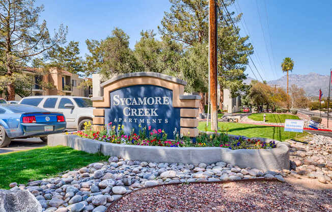 A sign for Sycamore Creek Apartments is in front of a grassy area.