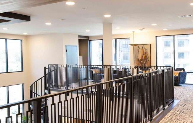 A black metal railing in a spacious room with a painting hanging on the wall.