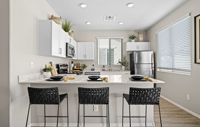 an open kitchen with a large island with three black stools