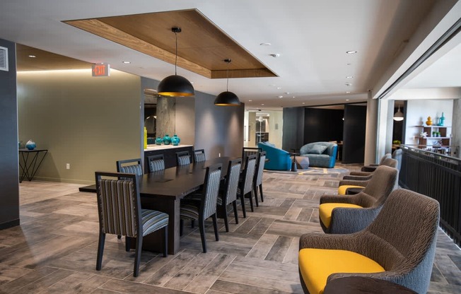 a long dining table with chairs in a lobby