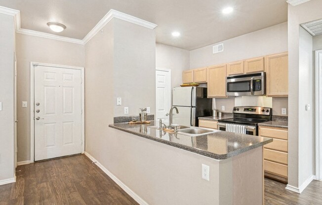 an empty kitchen with a counter top and a sink