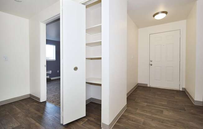 a bedroom with a medium hardwood floor and white walls