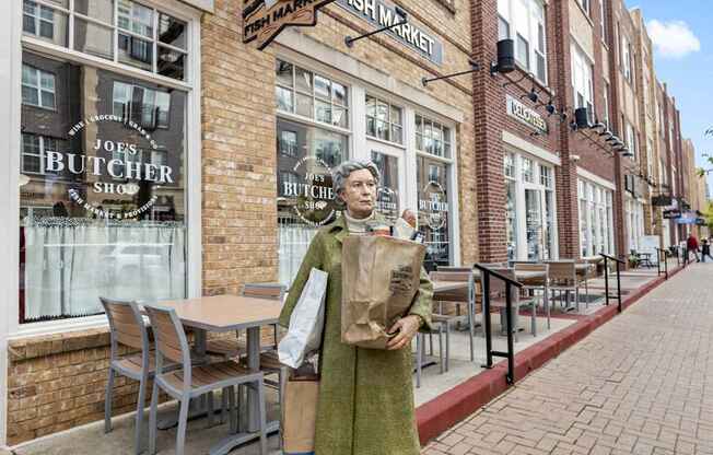 a woman standing on a sidewalk in front of a brick building