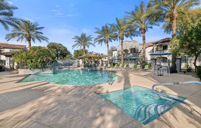 A swimming pool surrounded by palm trees and lounge chairs.
