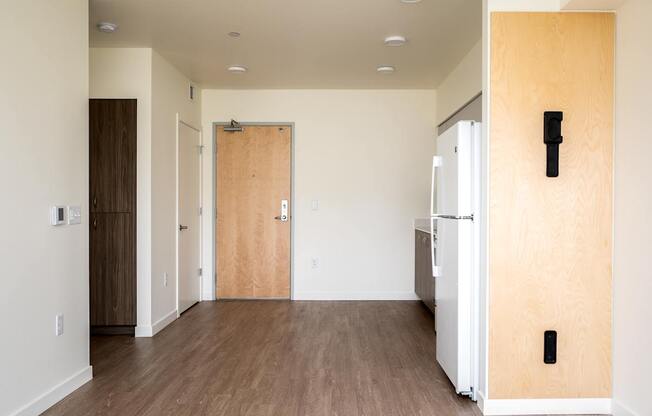 an empty room with a refrigerator and a door