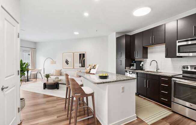 A modern kitchen with dark brown cabinets and stainless steel appliances.