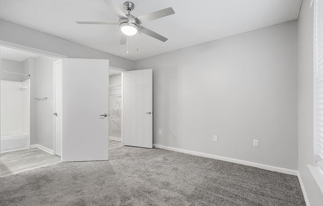 an empty room with white walls and a ceiling fan