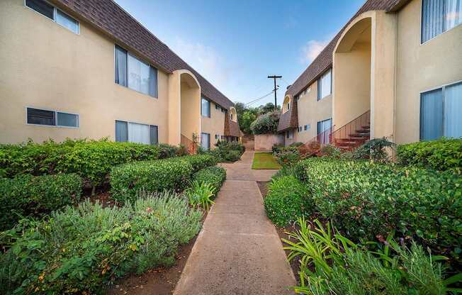 the walkway between the units is lined with plants and bushes