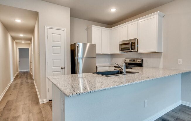 a kitchen with a counter top and a stainless steel refrigerator