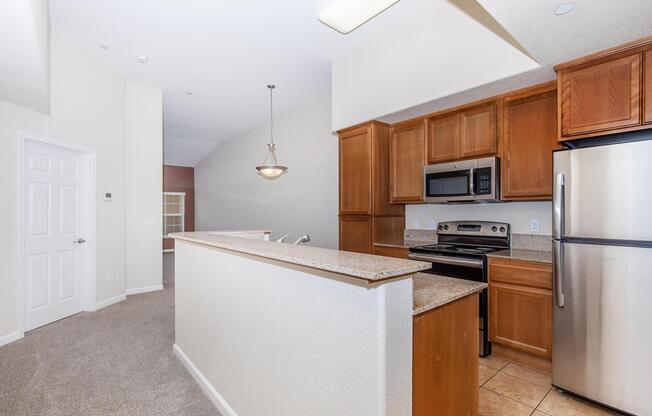 a large kitchen with stainless steel appliances and wooden cabinets