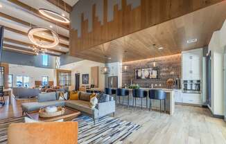 A modern living room with a large couch and a kitchen area in the background.