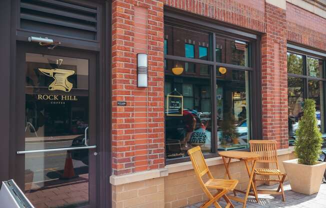 a brick building with tables and chairs outside of rock hill cafe