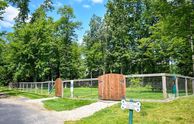 a gate in a fenced in area with trees in the background