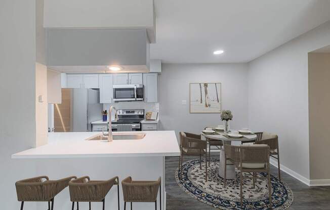 A kitchen with a dining table and chairs.