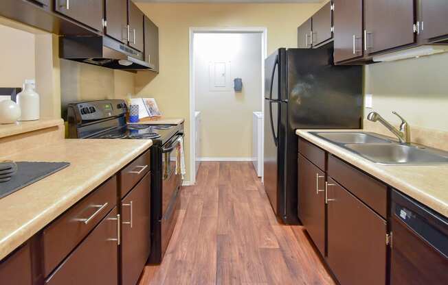 a kitchen with a black refrigerator freezer next to a stove top oven  at Riverset Apartments, Tennessee