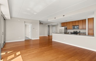 a large living room with a kitchen and a hard wood floor