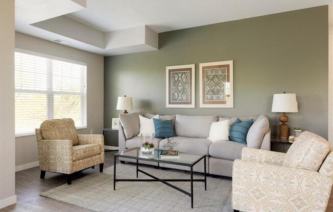 A living room with a sofa, two chairs, and a coffee table.