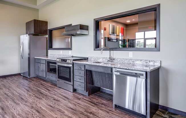 Community room kitchen with stainless steel appliances and a counter top