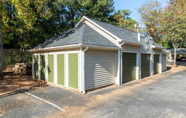 A small house with a grey roof and green doors.