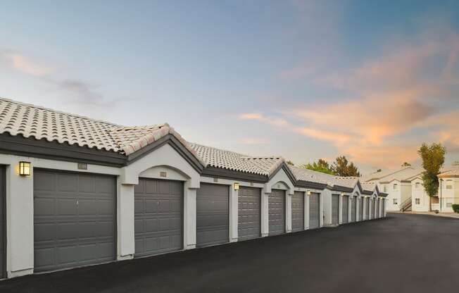 a row of garages with a sunset in the background